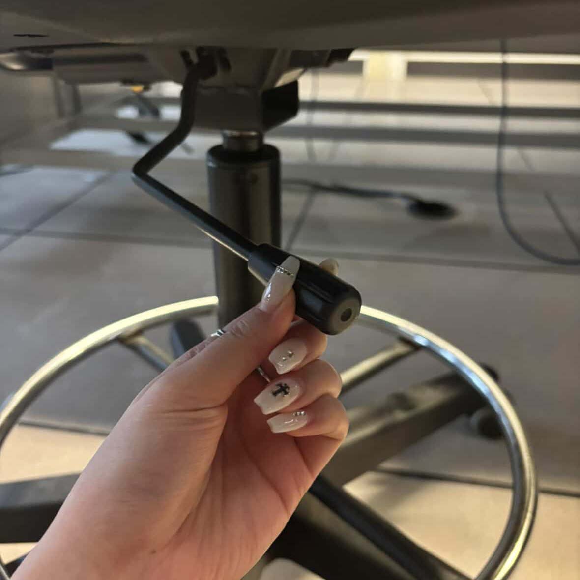 This is the lever underneath the chair's at school that can adjust the height of the chair. This is Chloe leaving the lever in a resting position.