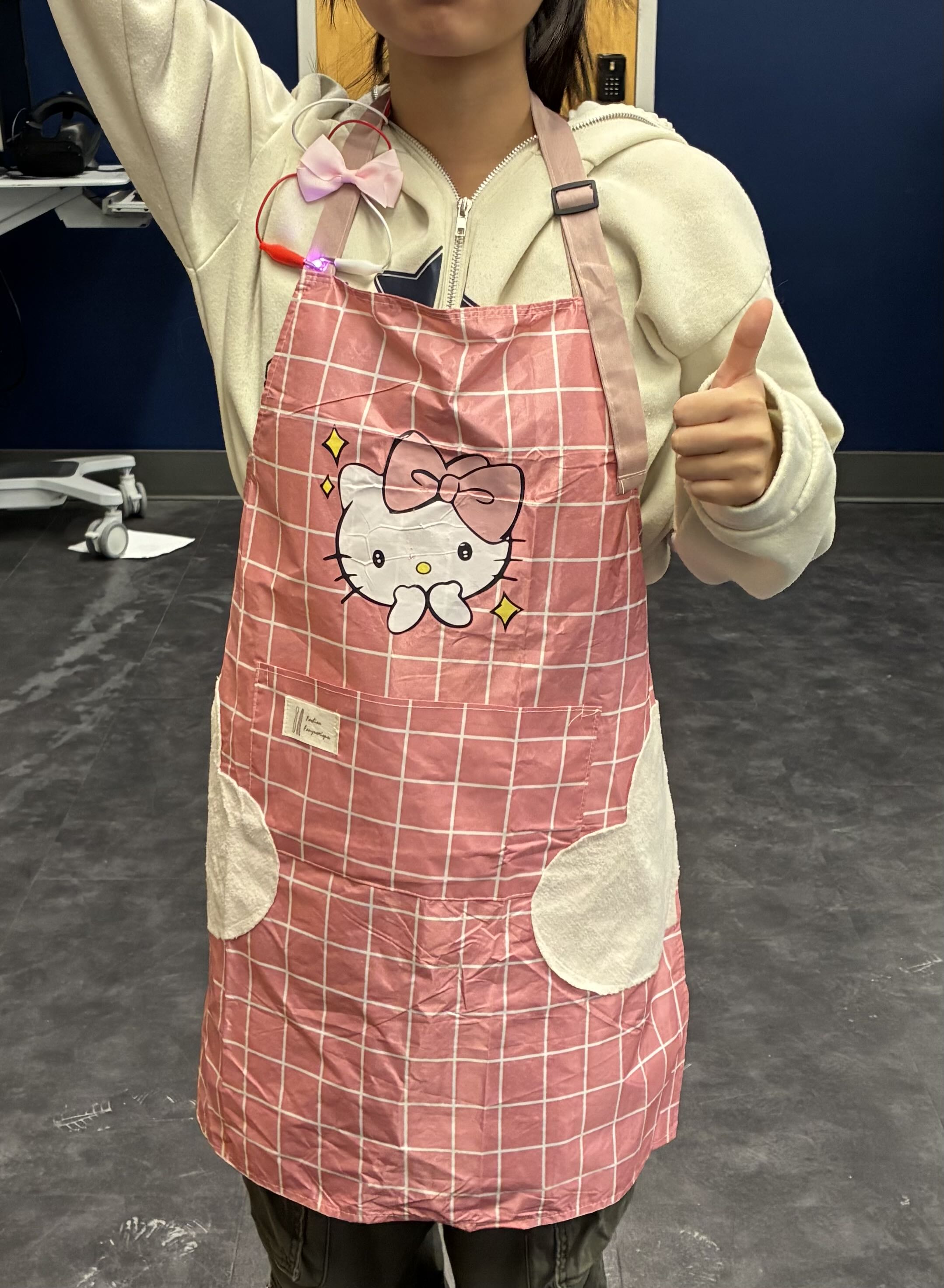 My wearable interactive affordance based circuit is a simple circuit made from alligator clips since copper tape had a hard time sticking to the fabric of the apron. The red wire has the battery taped to it and the white wire is clipped right behind the battery. Once the apron is put on the battery presses against the white wire making the light turn on. 