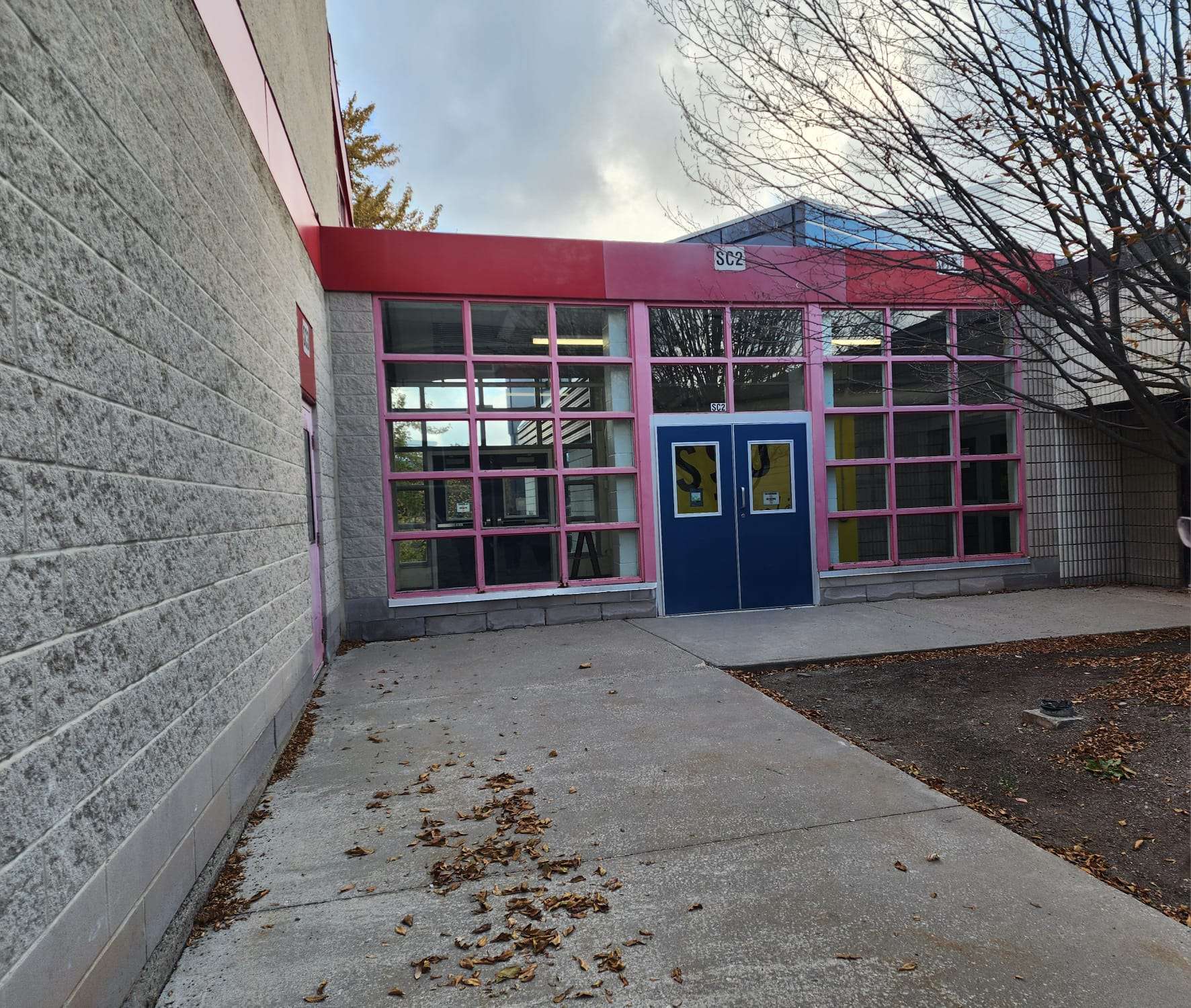 When entering the Marquee through the side door it is a very brutalist design. The concrete gives texture and the windows have pink outlines. The door is blue which creates contrast between the pinks and greys in the area. The marquee side food is not very visible or identifiable. Adding more bright colours like potted plants could create a more welcoming environment.