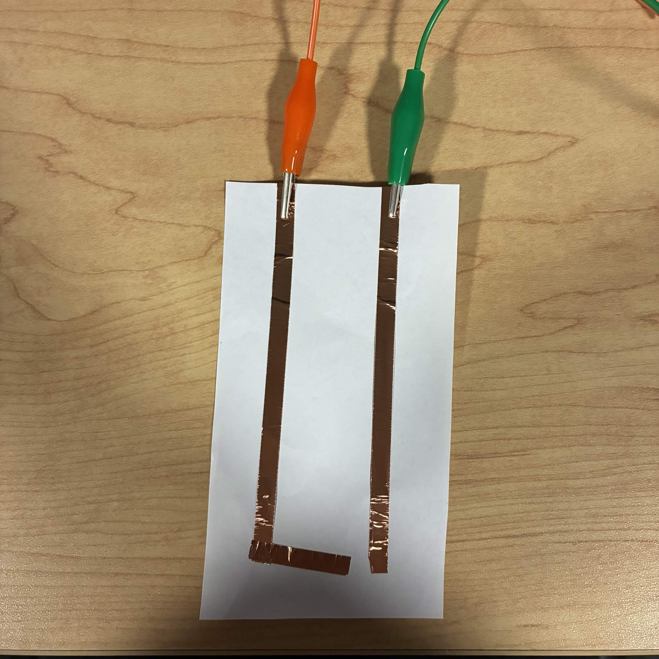 This is a close up of what the simple circuit looks like.The green wire is connected to the ground and the orange wire is connected to the down button.